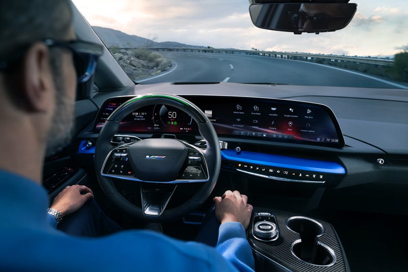 Front View of the 2026 OPTIQ-V Driving Through the Dusk Utilizing its Headlights | Bill Dodge Cadillac in Westbrook ME