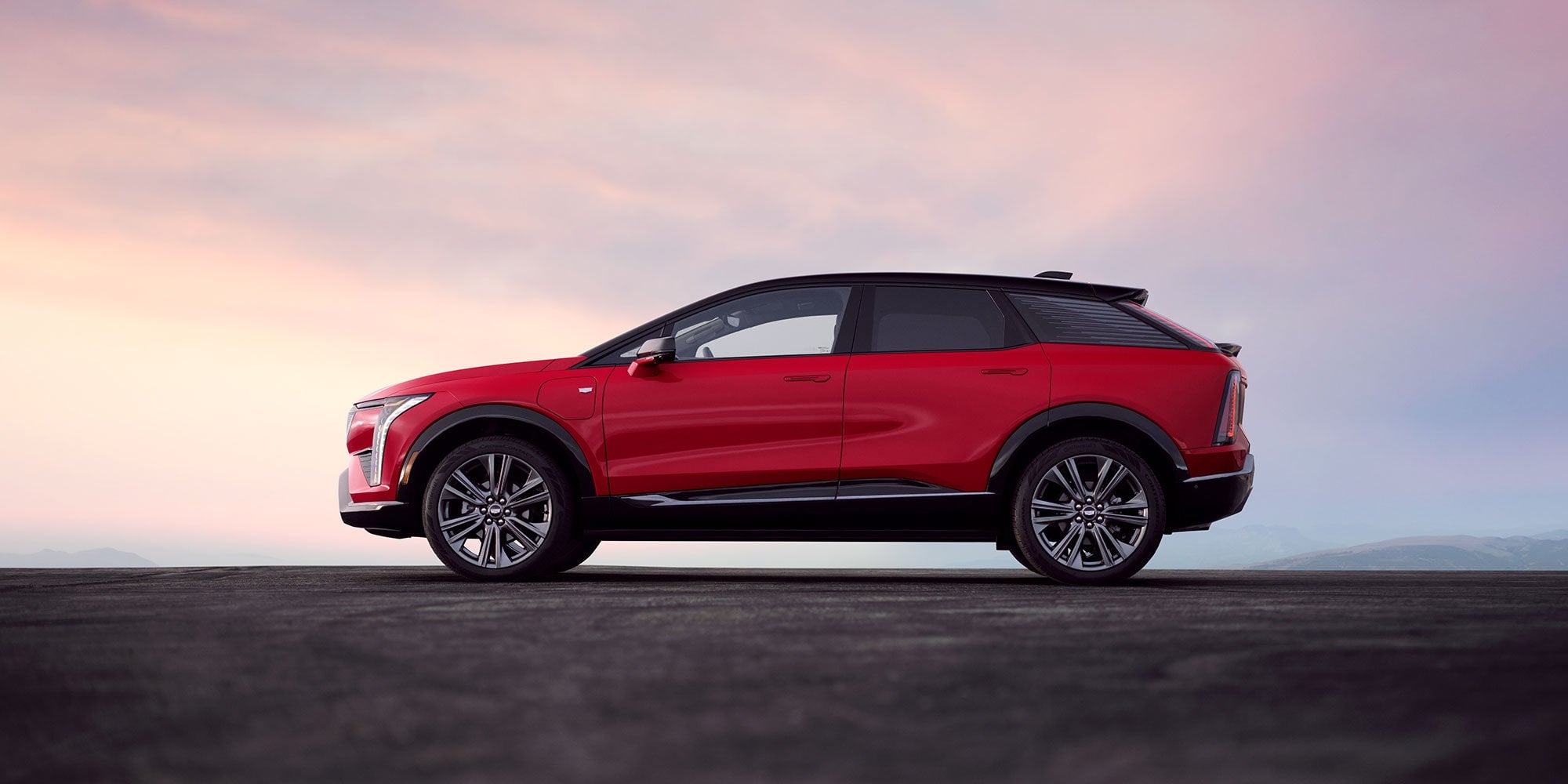 A red Cadillac OPTIQ in profile